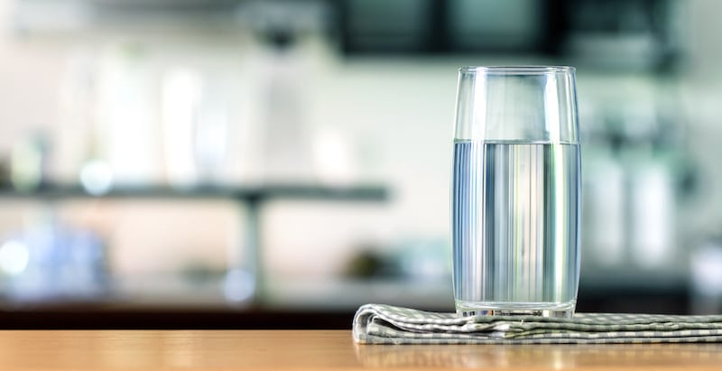 Glas mit frischem Wasser auf Küchenzeile